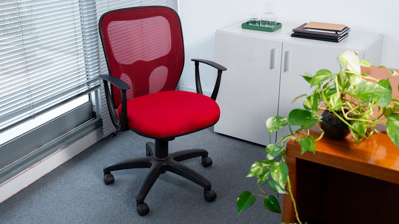 A red office chair in a corner  AI-generated content may be incorrect.