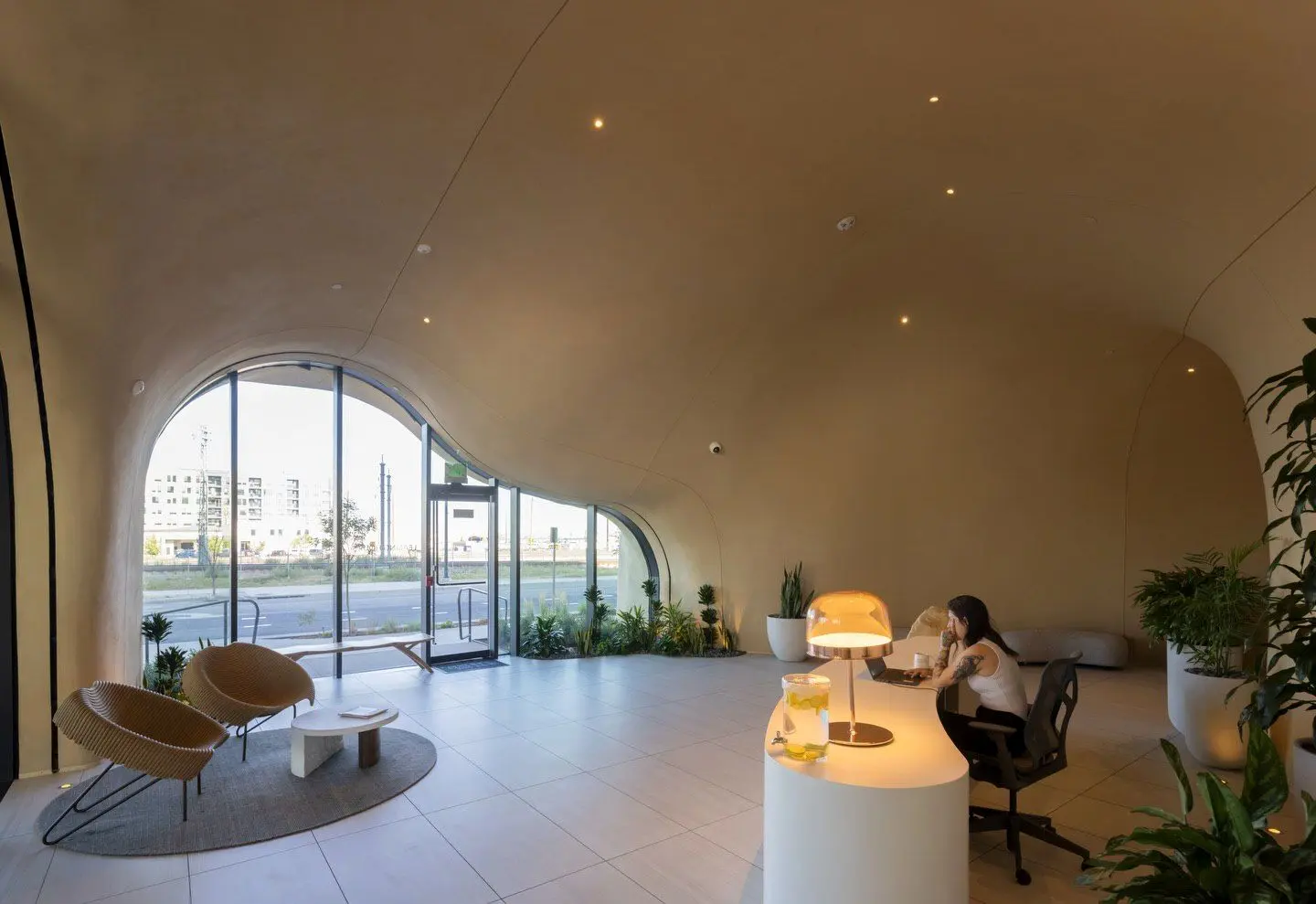 نمای ساختمان وان ریور نورث در دنور با نمای شیشه‌ای و شکاف عمیق صخره‌ای مجهز به گیاهان طبیعی و مسیر پیاده‌روی عمودی.