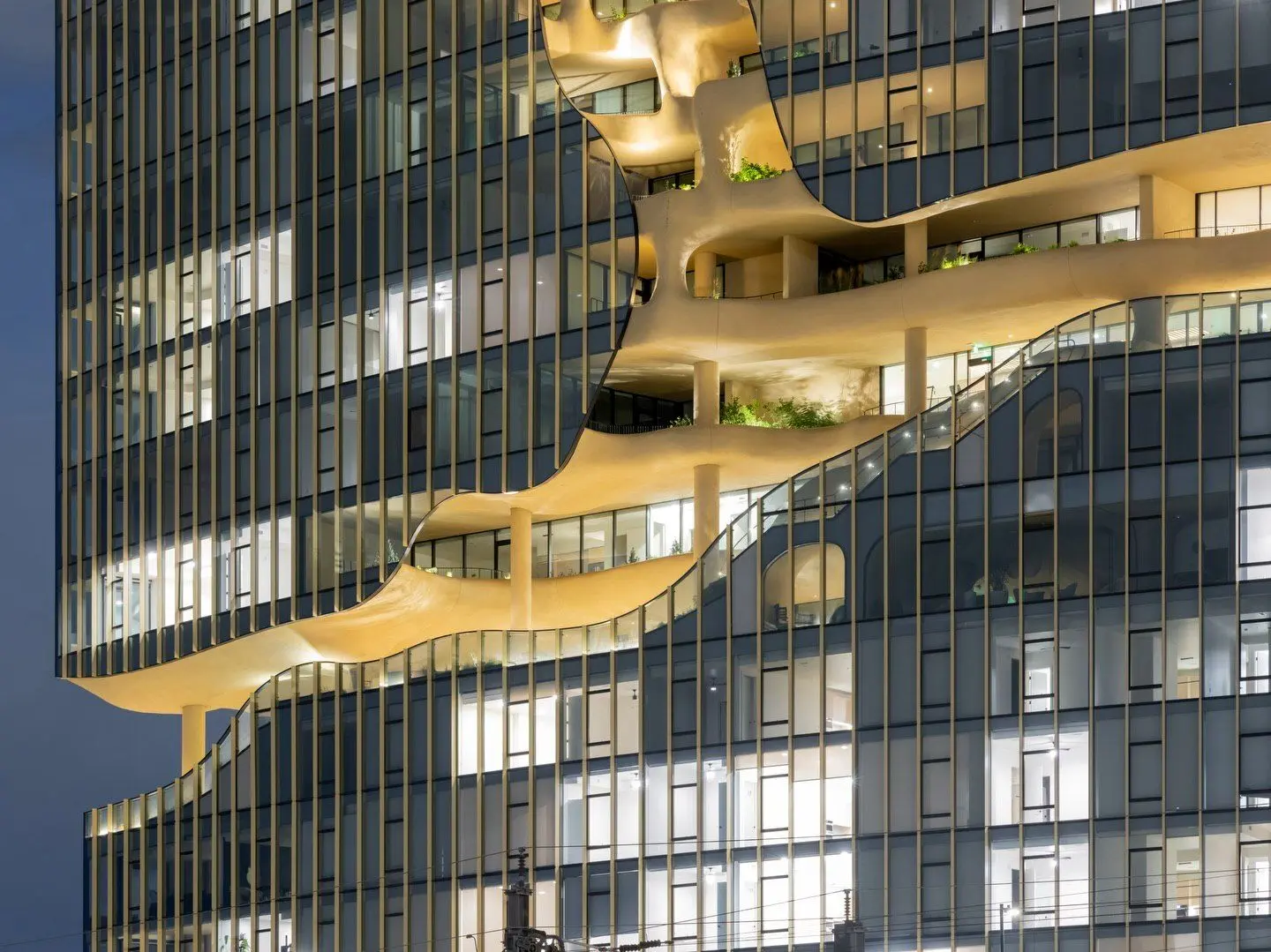 نمای ساختمان وان ریور نورث در دنور با نمای شیشه‌ای و شکاف عمیق صخره‌ای مجهز به گیاهان طبیعی و مسیر پیاده‌روی عمودی.