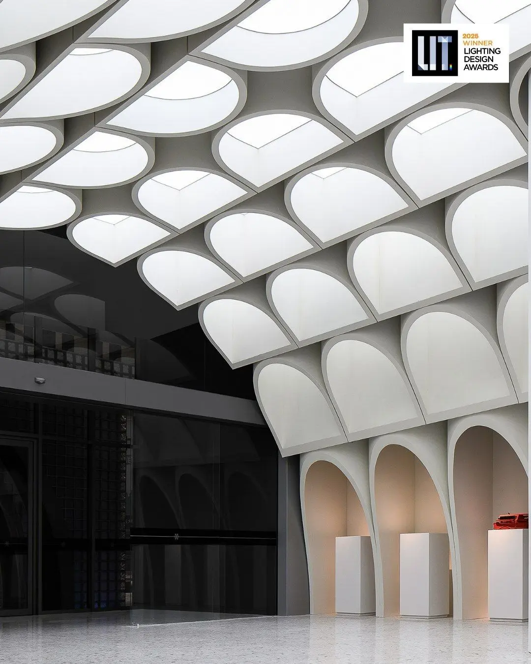 طراحی داخلی و نورپردازی مرکز طراحی خلاق هاربین برنده جایزه LIT که سایه‌های حروف و فرم‌های نامنظم را در فضای استودیو و گالری نشان می‌دهد.