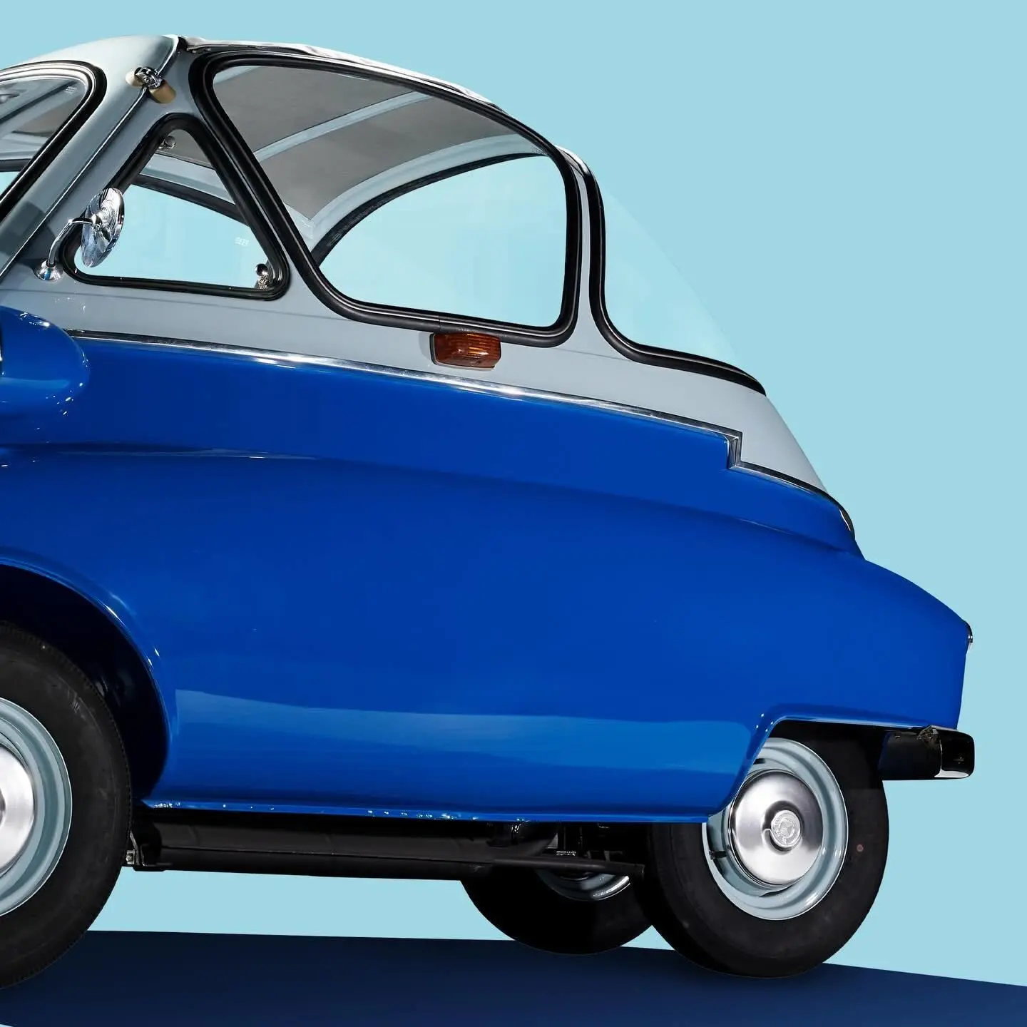تصویر یک خودروی مینیاتوری کلاسیک به نام BMW Isetta (ب‌ام‌و ایزتا) که به دلیل طراحی گرد و کوچک خود به "خودروی حبابی" (Bubble Car) مشهور است، و در دهه ۱۹۵۰ نقش کلیدی در نجات مالی شرکت ب‌ام‌و از ورشکستگی ایفا کرد.