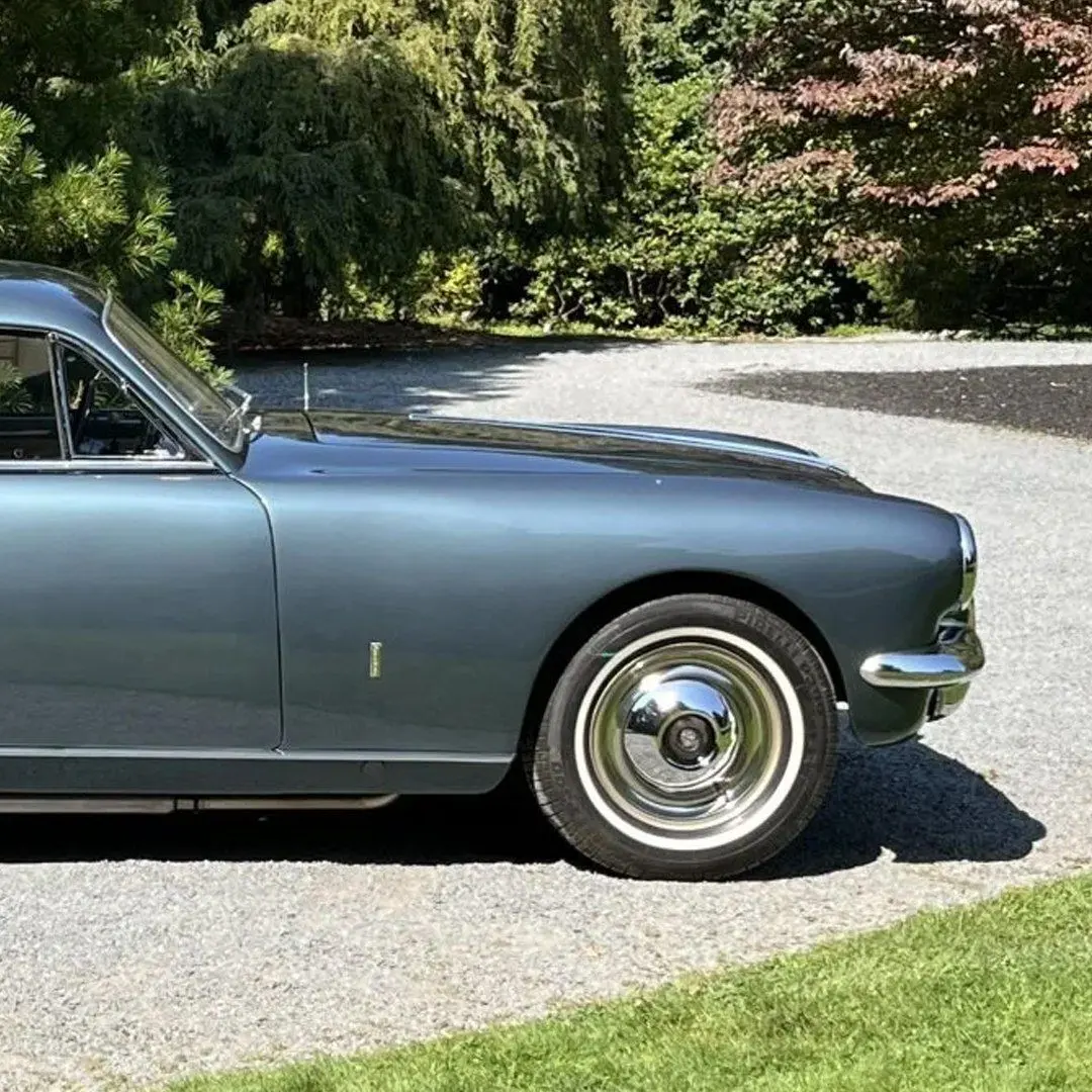 نمای کناری خودروی کلاسیک سیزیتالیا ۸۰۸XF مدل ۱۹۵۲ به رنگ آبی متالیک با طراحی بدنه گیا و رینگ‌های کلاسیک کرومی در فضای باز.