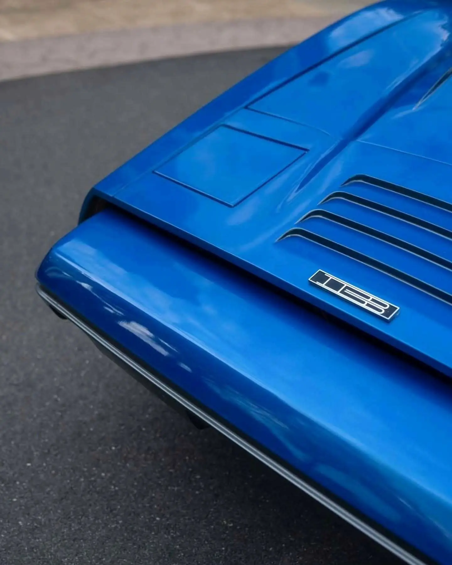 نمای جانبی خودروی کلاسیک بریکلین SV-1 با درهای باز شده رو به بالا و بدنه آکریلیک نارنجی رنگ که طراحی ایمن و آیرودینامیک آن را نشان می‌دهد.