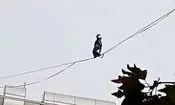 حرکت خطرناک دختر جوان روی سیم‌های بین ساختمان/ ویدئو