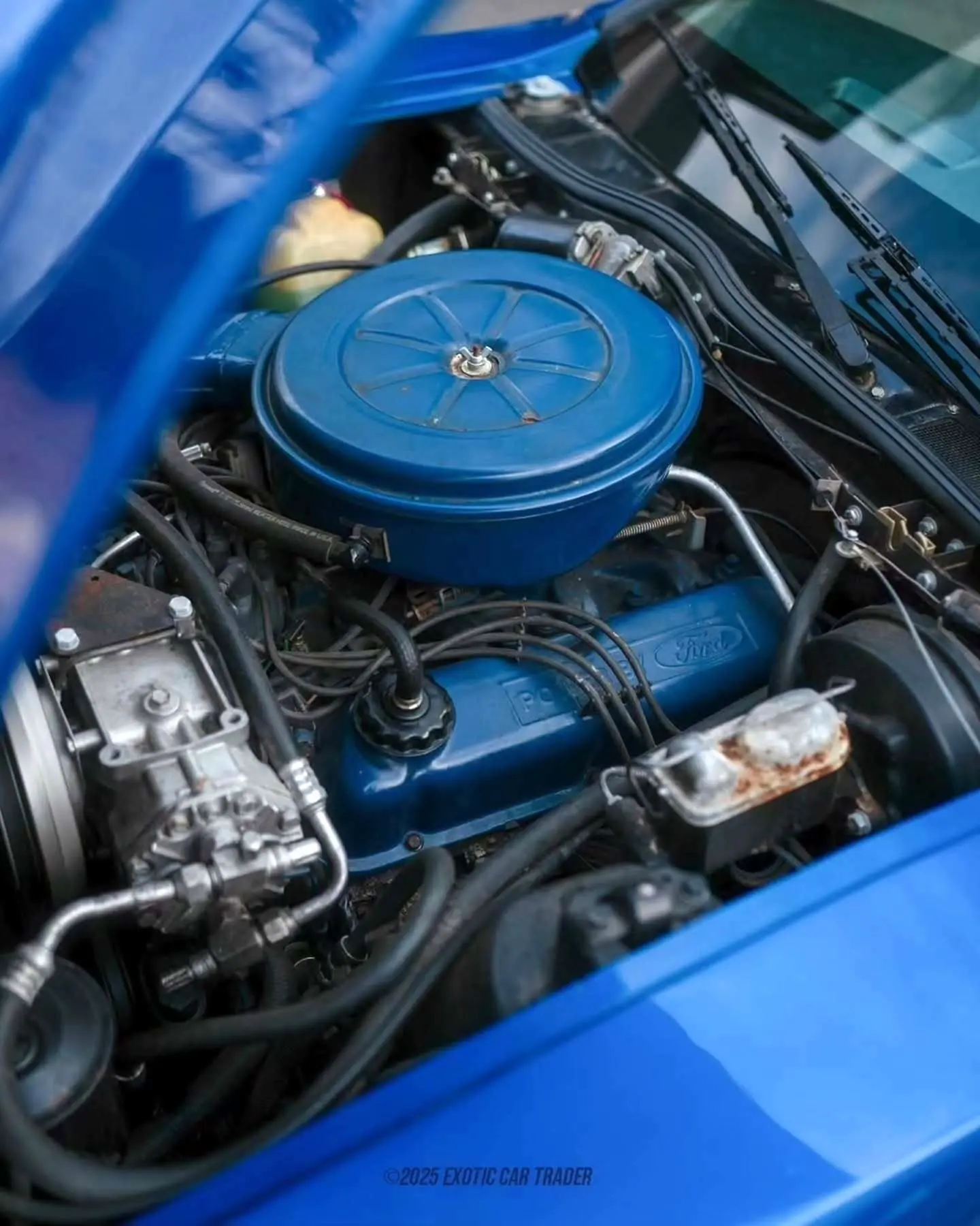 نمای جانبی خودروی کلاسیک بریکلین SV-1 با درهای باز شده رو به بالا و بدنه آکریلیک نارنجی رنگ که طراحی ایمن و آیرودینامیک آن را نشان می‌دهد.