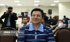 حسین هدایتی با دستبند و ماسک در راهرو دادگاه کیفری تهران