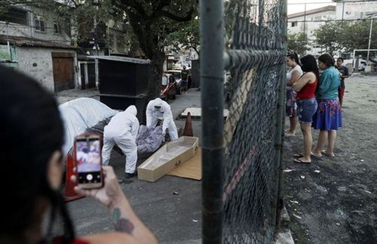 عکس تکان دهنده از برزیل؛ بازی فوتبال در کنار جسد کرونایی در خیابان + عکس