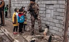 عکسی وحشتناک از جسد یک داعشی در موصل/ این جسد جاذبه ای هولناک برای کودکان عراقی شد (16+)