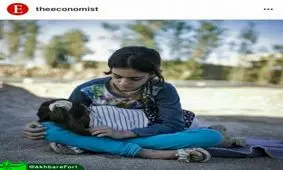 دختر بچه‌ای که خواهر خردسالش را در سرپل ذهاب به آغوش گرفته است + تصویر