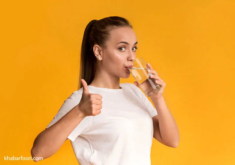 دختر جوانی در حال نوشیدن آب