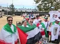 پرچم ایران و فلسطین و تصاویر شهدای میناب در دست هواداران تیم ملی