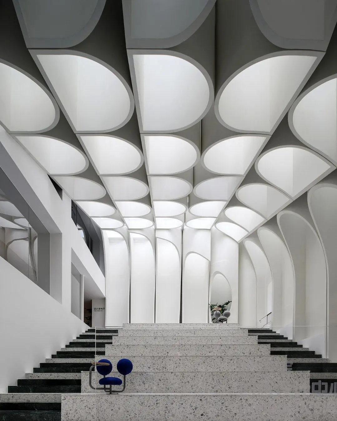 طراحی داخلی و نورپردازی مرکز طراحی خلاق هاربین برنده جایزه LIT که سایه‌های حروف و فرم‌های نامنظم را در فضای استودیو و گالری نشان می‌دهد.