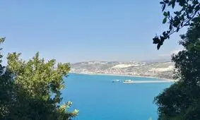 تصویری خاص از قدم زدن زن و مردی در ساحلی در لبنان و پس زمینه حملات اسرائیل