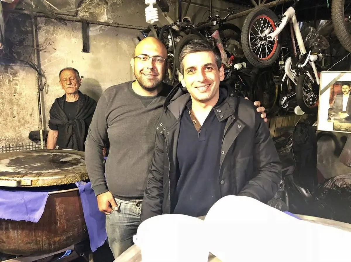 حمید گودرزی در کنار دیگ نذری در روز اربعین 