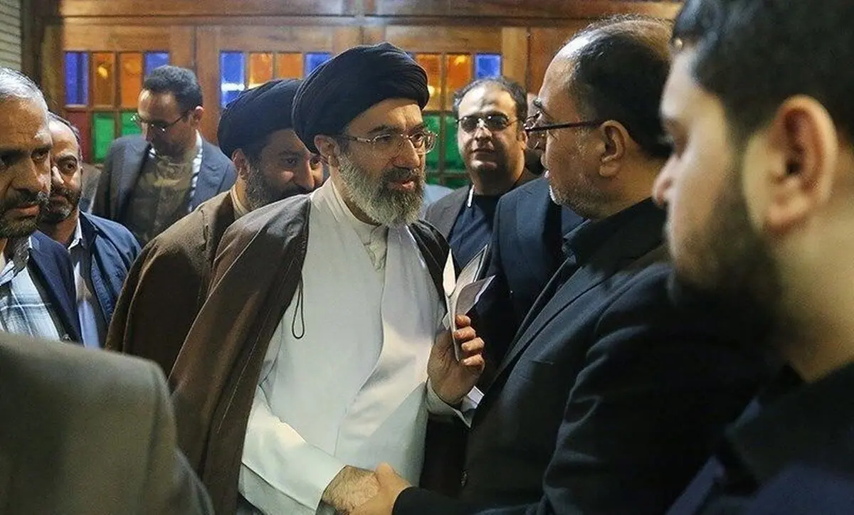  پدر روح‌الله زم در حال احوالپرسی با فرزند رهبر انقلاب/ عکس

