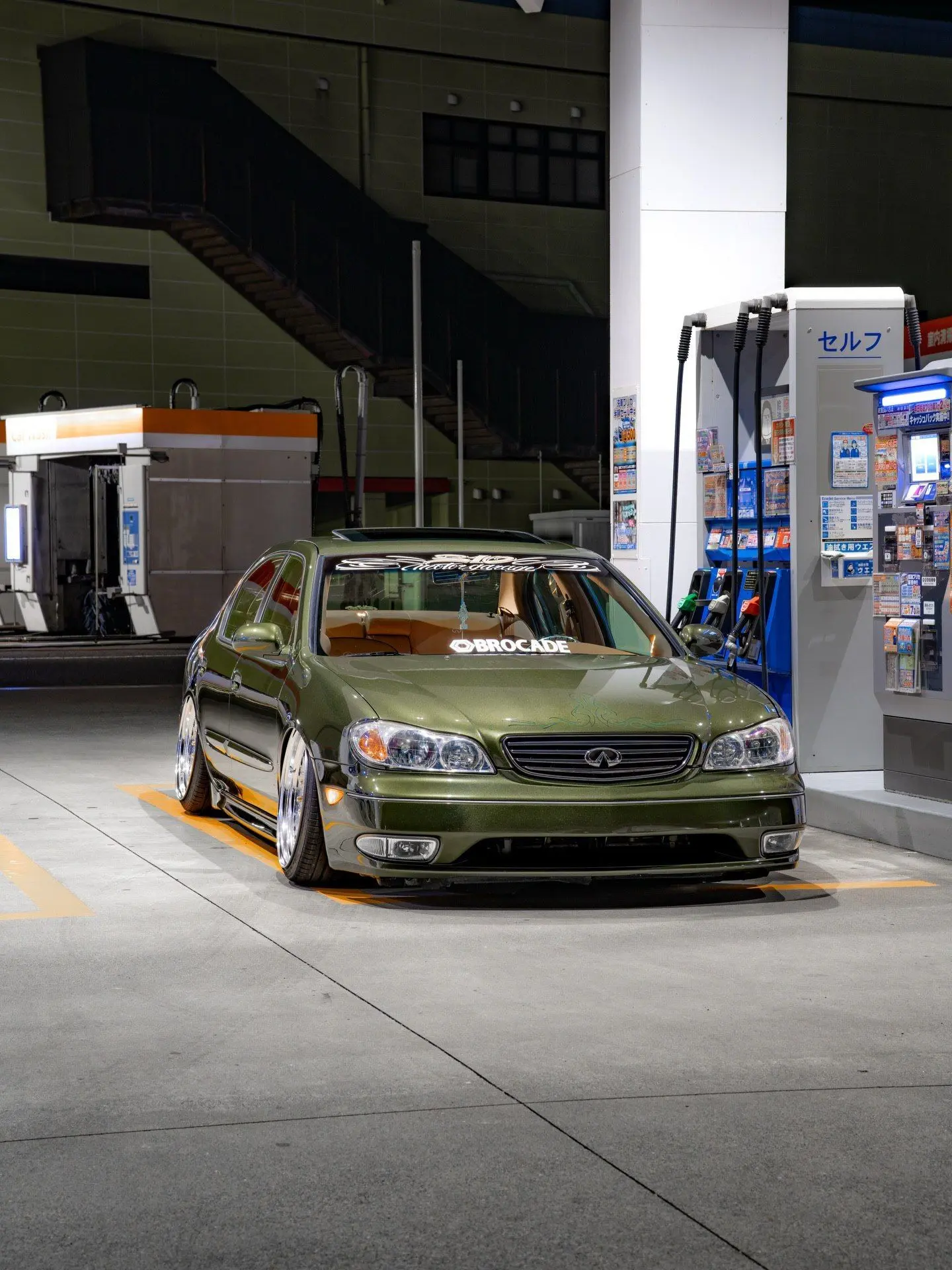 نمای خارجی خودروی تیونینگ شده اینفینیتی I35 با رینگ‌های Brocade، سیستم تعلیق بادی کاهش ارتفاع یافته و تزئینات پین‌استرایپ روی بدنه.