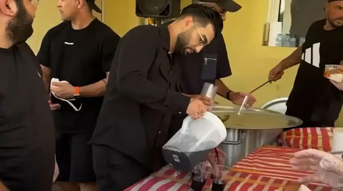 حسین تهی در حال توزیع نذری در روز عاشورا/ ویدئو 