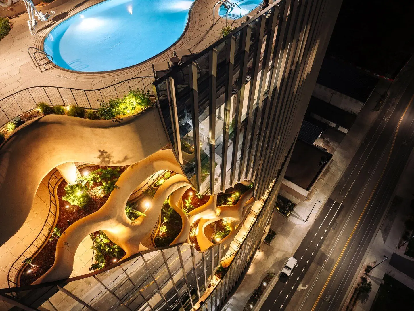 نمای ساختمان وان ریور نورث در دنور با نمای شیشه‌ای و شکاف عمیق صخره‌ای مجهز به گیاهان طبیعی و مسیر پیاده‌روی عمودی.