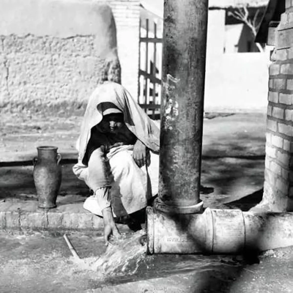 پیرمرد تهرانی در حال پر کردن کوزه از آب چاه؛ سال ۱۳۴۰