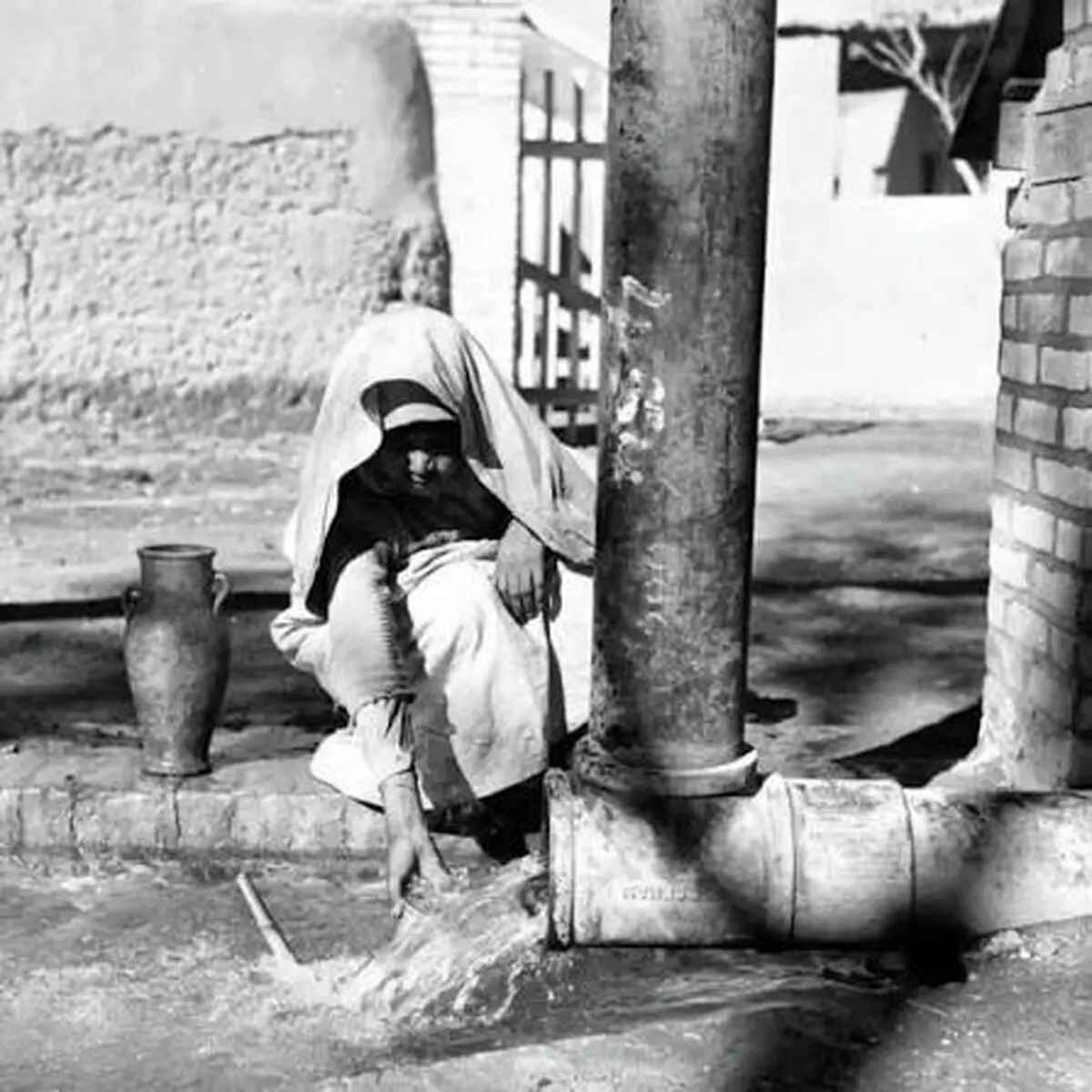 پیرمرد تهرانی در حال پر کردن کوزه از آب چاه؛ سال ۱۳۴۰
