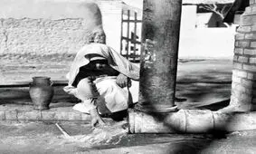 پیرمرد تهرانی در حال پر کردن کوزه از آب چاه؛ سال ۱۳۴۰