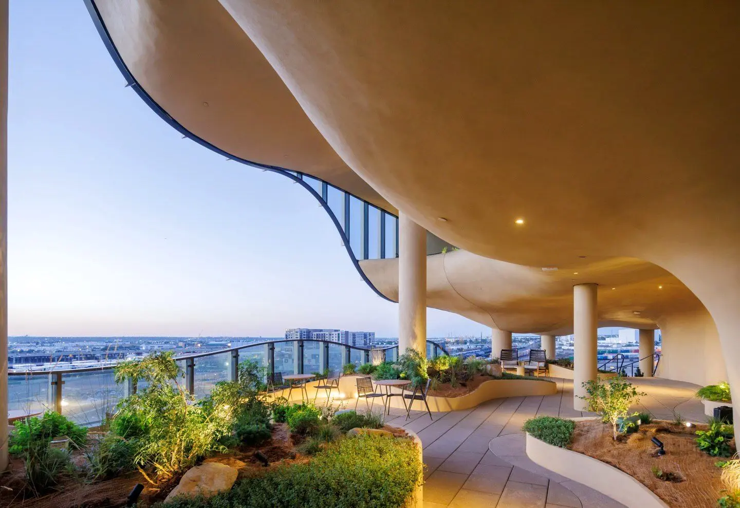 نمای ساختمان وان ریور نورث در دنور با نمای شیشه‌ای و شکاف عمیق صخره‌ای مجهز به گیاهان طبیعی و مسیر پیاده‌روی عمودی.