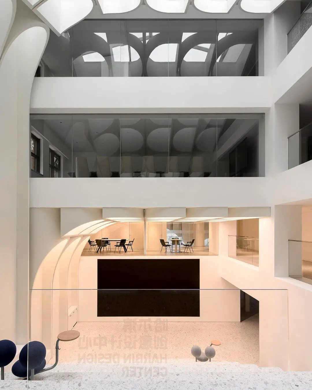 طراحی داخلی و نورپردازی مرکز طراحی خلاق هاربین برنده جایزه LIT که سایه‌های حروف و فرم‌های نامنظم را در فضای استودیو و گالری نشان می‌دهد.