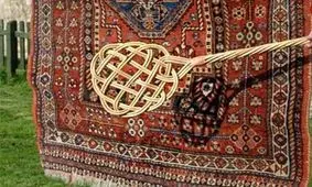 سفر به ایران قدیم؛ مرد اصفهانی در حال تکاندن قالی‌ها با چوب؛ سال 1340