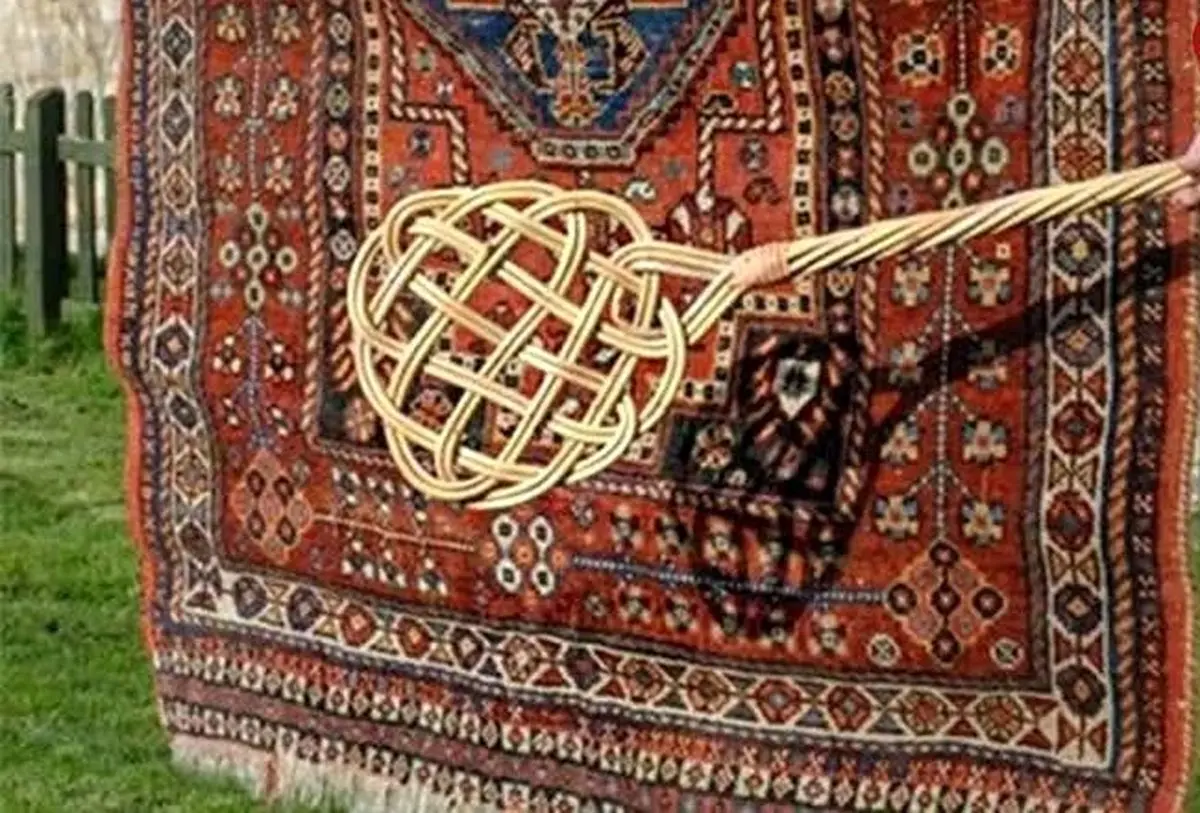 سفر به ایران قدیم؛ مرد اصفهانی در حال تکاندن قالی‌ها با چوب؛ سال 1340