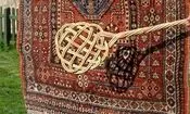 سفر به ایران قدیم؛ مرد اصفهانی در حال تکاندن قالی‌ها با چوب؛ سال 1340