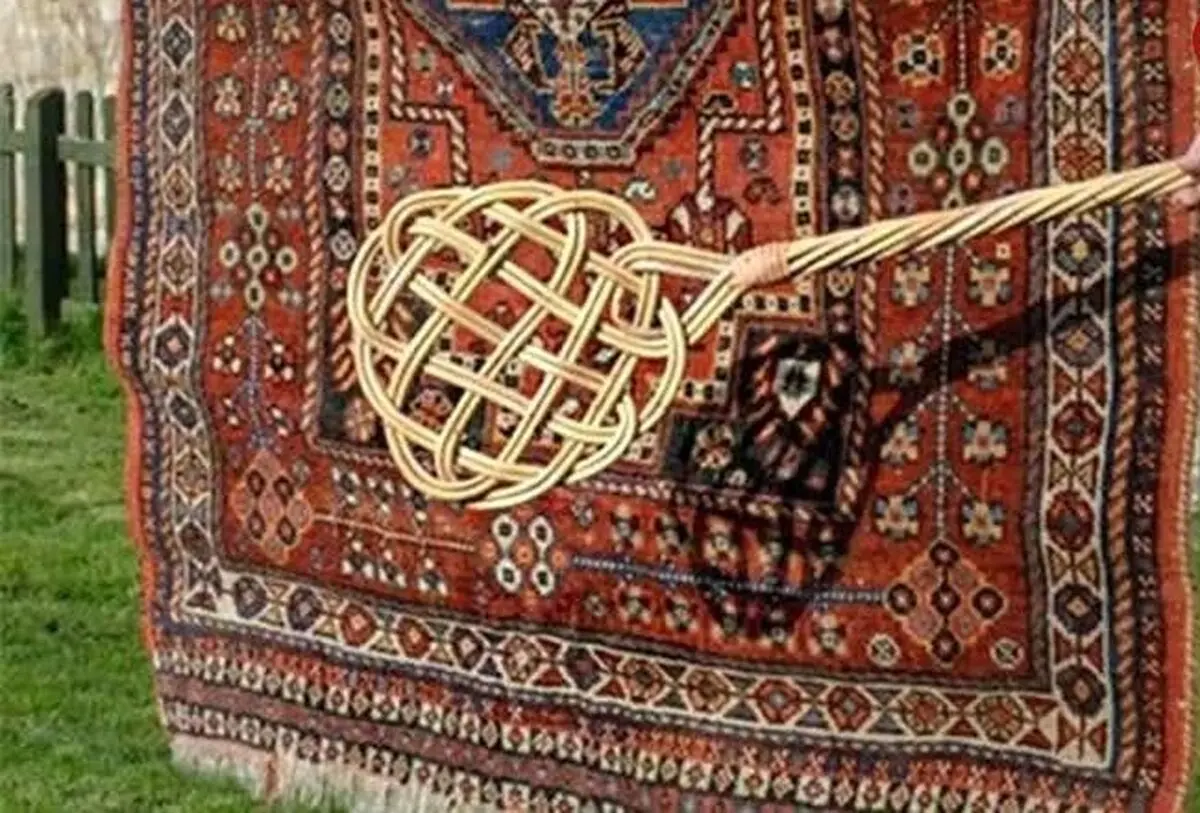سفر به ایران قدیم؛ مرد اصفهانی در حال تکاندن قالی‌ها با چوب؛ سال 1340